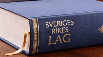 Bild på Sveriges Rikes Lag liggandes på ett skrivbord. Bilden ska illustrera ett domslut i ett ärende om spelavtal.