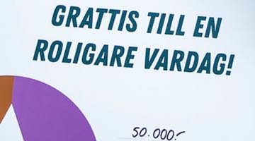 Bild som visar en del av en vinstcheck från Miljonlotteriet. På checken står det "Grattis till en roligare vardag!" lite längre ner står vinstbeloppet "50 000 kr"